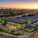 Fachada de um moderno supermercado Pão de Açúcar com logotipo verde ao pôr do sol, representando ativos imobiliários do fundo GARE11. Imagem ilustrativa