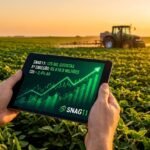 SNAG11 Alcança 125 Mil Cotistas e Acelera com 5ª Emissão de Cotas: O que Você Precisa Saber 4 Homem segurando um tablet em uma plantação de soja ao pôr do sol, exibindo gráficos de crescimento do Fiagro SNAG11 com dados sobre 125 mil cotistas e 5ª emissão.